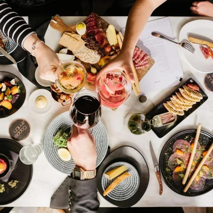 Friends sharing a grazing table of plates and wine