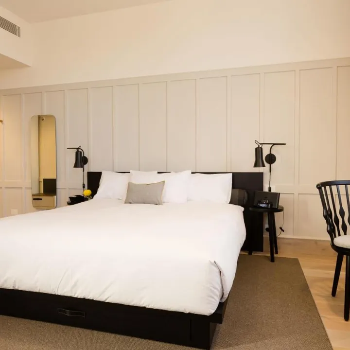 King room with panelled walls and crisp white linen