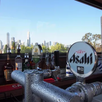 Rooftop bar beer taps with the Melbourne city skyline through the window